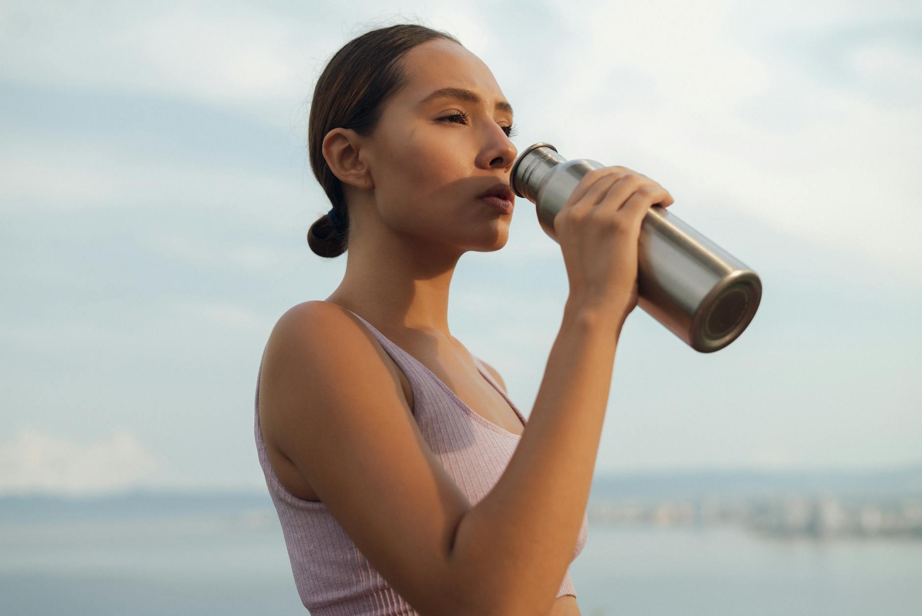 fit woman drinking from thermos